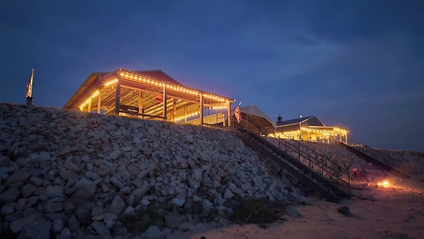 A building with a covered outdoor area, stairs leading up to it, and a pile of rocks in the foreground. - Reconnect with nature at this unforgettable escape (RV NOT INCL'D). (Clifton)