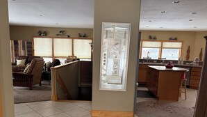 Un vaste espace de vie comprenant un canapé, une table basse en bois et un coin cuisine doté d’un grand îlot central.