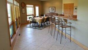Une cuisine spacieuse avec un coin repas, comprenant un grand îlot central, des chaises et une table.