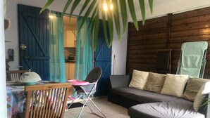 Una habitación acogedora con una mesa de comedor de madera, una trona, un sofá y una puerta azul.