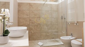 Une salle de bain moderne avec un grand lavabo blanc, un bidet et un espace douche.
