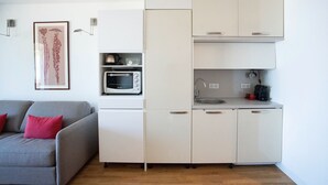 A compact kitchen with white cabinets, a microwave, and a coffee maker. - *STUDIO BASIN VIEW*DIRECT ACCESS TO THE BEACH* (Arcachon)