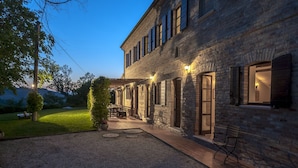 Edificio de ladrillo con patio, mobiliario exterior y vistas del paisaje circundante.