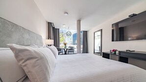 Een moderne hotelkamer met een groot bed, een bureau, een stoel en een televisie.