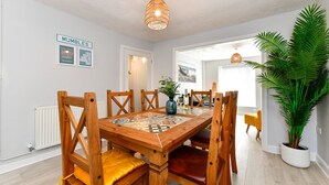 A dining area with a wooden table, chairs, and a decorative vase. - Just Stay Wales - Hartwell House Mumbles (Swansea)