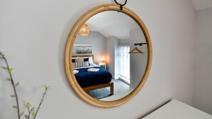A bedroom with a bed, bedside table, lamp, and a hanging light fixture. - Just Stay Wales - Hartwell House Mumbles (Swansea)