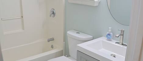Un baño con bañera, inodoro y lavamanos.