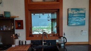 A kitchen with a wooden countertop, a sink, and a window with a view of greenery. - Your Lake & Mountain vacation awaits... (Sagle)