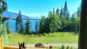 A window view of a lake with trees and mountains in the background. - Your Lake & Mountain vacation awaits... (Sagle)