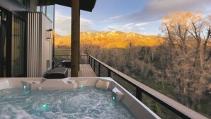 Ein Whirlpool auf einem Balkon mit Blick auf die Berge.