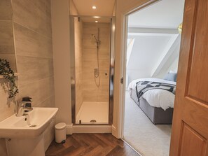 Casa de banho moderna com chuveiro, lavatório e sanita.