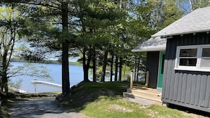 A cabin with a dock extending into a lake, surrounded by trees. - Spacious, three bedroom cottage on beautiful Lake Metonga. (Crandon)