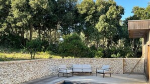 A swimming pool with a wooden deck, stone wall, and white lounge chairs. - Charming new villa for 6 people near sperone and bonifacio (BONIFACIO)
