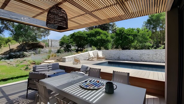 An outdoor patio with a pool, seating, and a view of the surrounding landscape. - Charming new villa for 6 people near sperone and bonifacio (BONIFACIO)