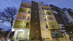 A multi-story residential building with balconies, a garage, and a security gate. - Treebo JJ Residency (Bengaluru)