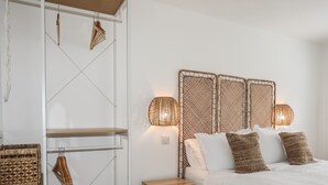 A bedroom with a bed, bedside lamps, a wooden nightstand, and wicker baskets on shelves. - A Mor (Llanfairpwllgwyngyll)