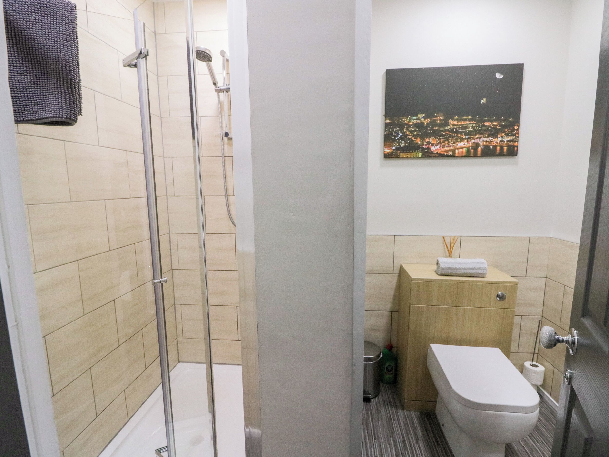 A bathroom with a glass-enclosed shower, a toilet, and a sink.