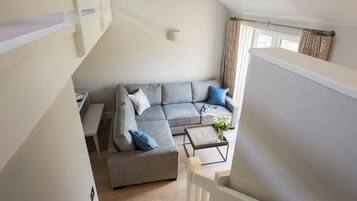 A modern living room with a grey sectional sofa, a small coffee table, and a white bench.