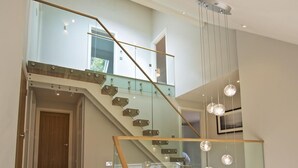 A modern staircase with glass railings and a wooden finish, leading to an upper floor. - 3 The Drive, Hillfield Village (Dartmouth)