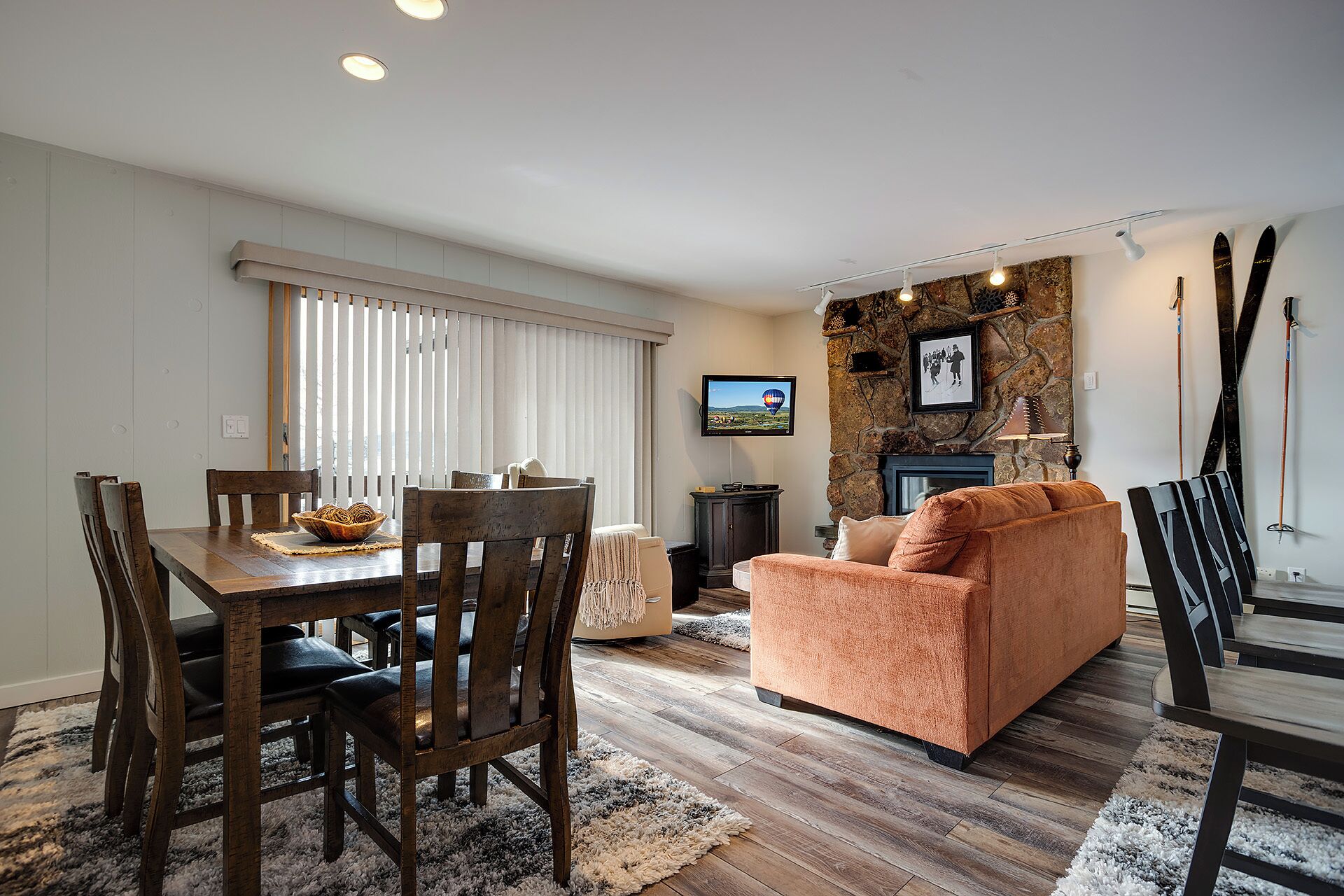 A living room with a fireplace, a television, and a stone wall.