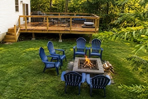 Un jardin avec une terrasse, un espace salon extérieur et un foyer.
