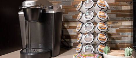 En Keurig-kaffemaskin och en hög med Dunkin'-kaffekapslar står på en köksbänk.