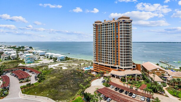 A high-rise hotel with multiple balconies, a pool area, and a view of the ocean. - Portofino Tower 1 | Sound View Escape (Pensacola Beach)