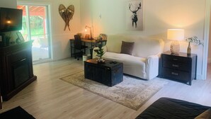 Ein Wohnzimmer mit einer Couch, einem Couchtisch, einem Fernseher und einem Kamin.