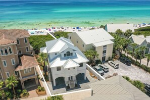 A coastal residential area with houses, a beach, and clear blue water.