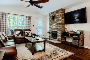 Relax in this stylish living room with a leather sofa, coffee table, and stone fireplace.