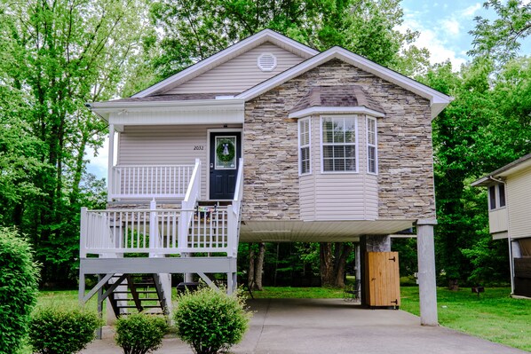 Step into this charming home, featuring a covered porch with a bench and a potted plant.