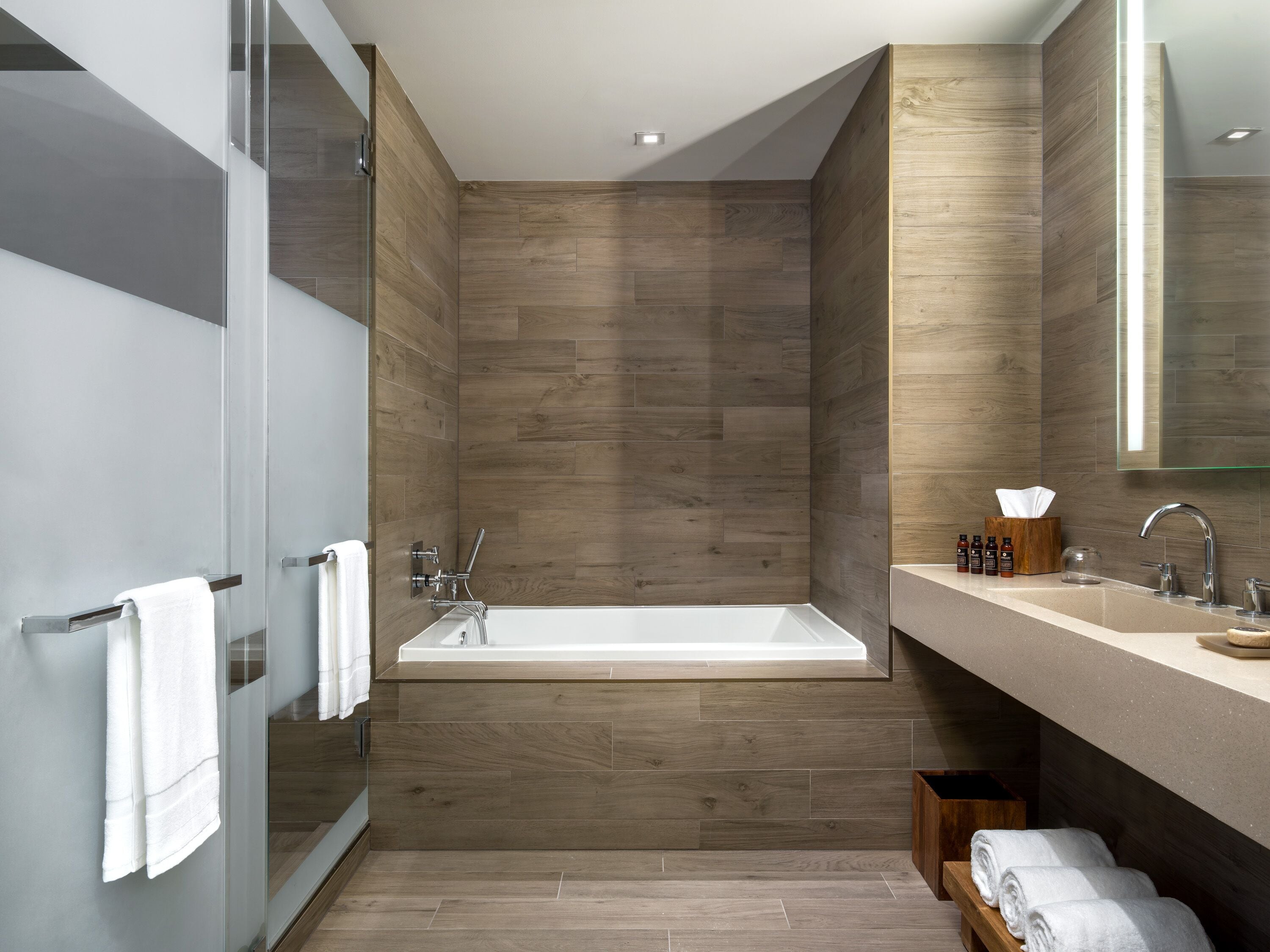 Une salle de bain moderne avec une baignoire sur pieds, une douche à parois de verre et un meuble-lavabo avec un miroir.