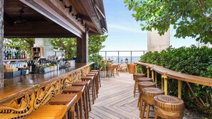 Un espace bar extérieur avec des meubles en bois et une vue sur la ville.