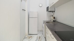 Cocina compacta con refrigerador, microondas y lavamanos.
