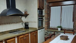 A kitchen with wooden cabinets, a stove, a microwave, and a dishwasher.