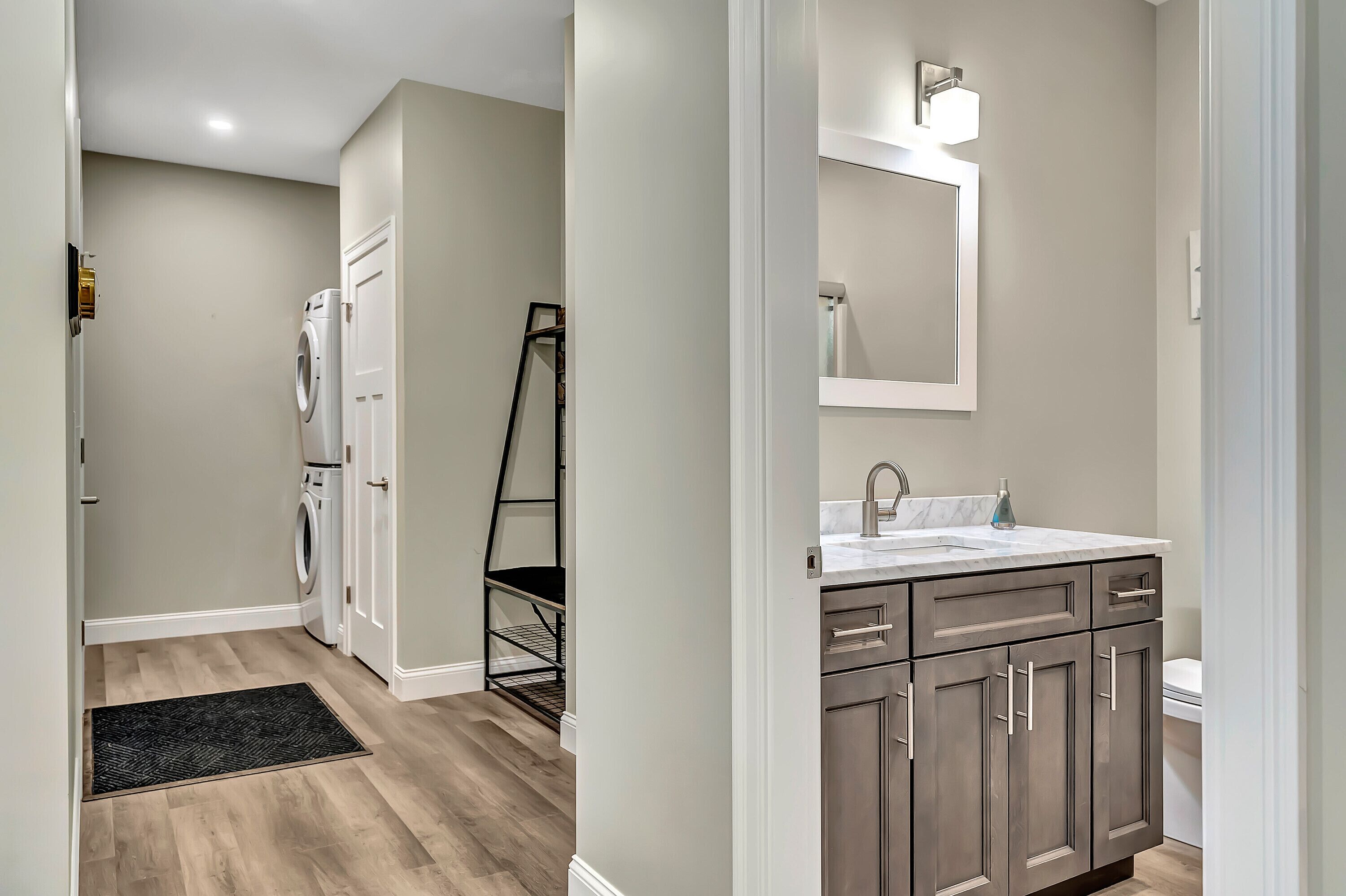 A modern bathroom with a sink, mirror, and toilet.