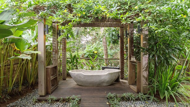 A wooden pergola structure with a stone bathtub in the center, surrounded by lush greenery and a pebble path. - Villa Lumia - 4BR · 20m Pool · Jacuzzi · Private Chef · Rice Fields · Ubud (Ubud)