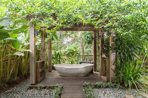 A wooden pergola structure with a stone bathtub in the center, surrounded by lush greenery and a pebble path. - Villa Lumia - 4BR · 20m Pool · Jacuzzi · Private Chef · Rice Fields · Ubud (Ubud)