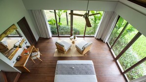 A room with a bed, a desk, and a view of the garden. - Villa Lumia - 4BR · 20m Pool · Jacuzzi · Private Chef · Rice Fields · Ubud (Ubud)