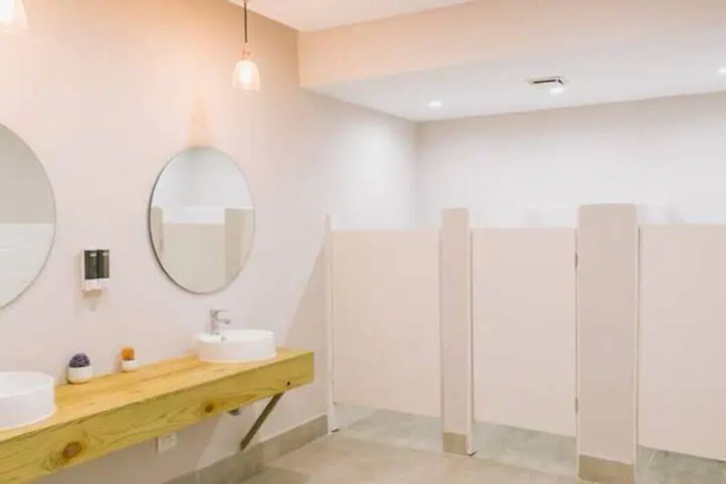 Ein modernes Badezimmer mit zwei Waschbecken, einem Spiegel und einer Duschkabine.