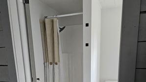 A bathroom with a shower, toilet, and a wooden floor. - 1-bedroom farm stay just 6 minutes to Ozark National Scenic Riverways (Eminence)
