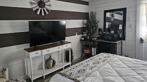 A bedroom with a TV on a white dresser, a clock, a plant, and a bed with a patterned blanket. - 1-bedroom farm stay just 6 minutes to Ozark National Scenic Riverways (Eminence)