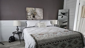 A bedroom with a bed, a nightstand, a wall-mounted fan, and a decorative wall piece. - 1-bedroom farm stay just 6 minutes to Ozark National Scenic Riverways (Eminence)