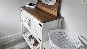A bathroom with a wooden vanity, a mirror, and a white laundry basket. - 1-bedroom farm stay just 6 minutes to Ozark National Scenic Riverways (Eminence)