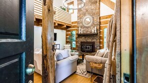 Ein gemütliches Wohnzimmer mit Kamin, Holzbalken und einer Steinwand.