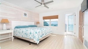 A bedroom with a bed, a ceiling fan, a window with blinds, and a door with a view. -  Gulf Front on a ISLAND, 1 pet, tennis, pickleball,sup,kayak. POOL is CLOSED (Placida)