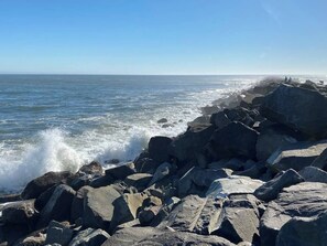 Un rivage rocheux où les vagues s’écrasent contre les rochers.