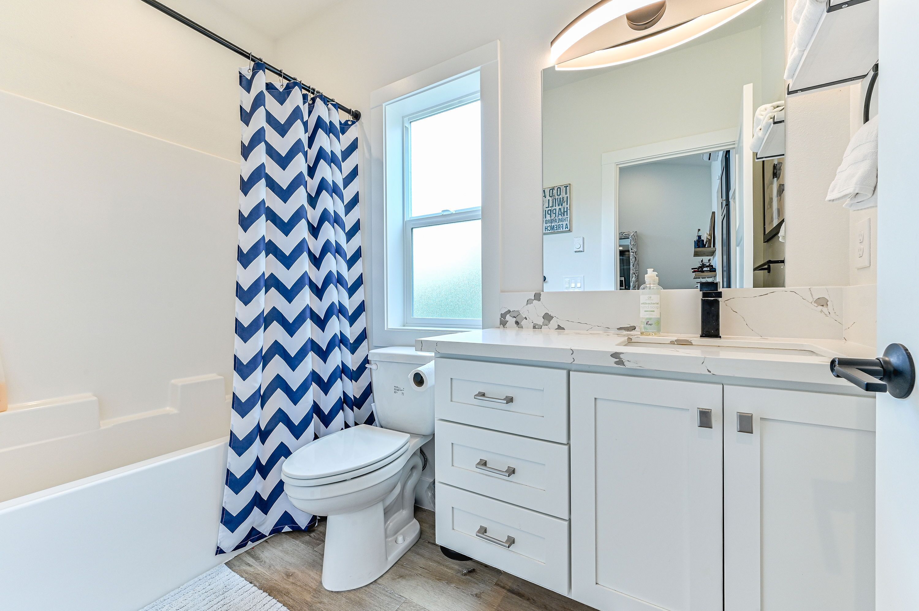 Run a bath after a long beach day — this is the second full bathroom, tub and shower both, for whoever's not in the king suite.