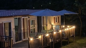 A two-story wooden cabin with a deck, glass sliding doors, and a covered patio area. - 25 Very large M-Home quiet nature air conditioning Bedarieux sleeps 4 (Bédarieux)