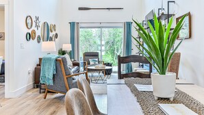 Una sala moderna con un sofá, sillones, una mesa de centro y una planta en maceta.